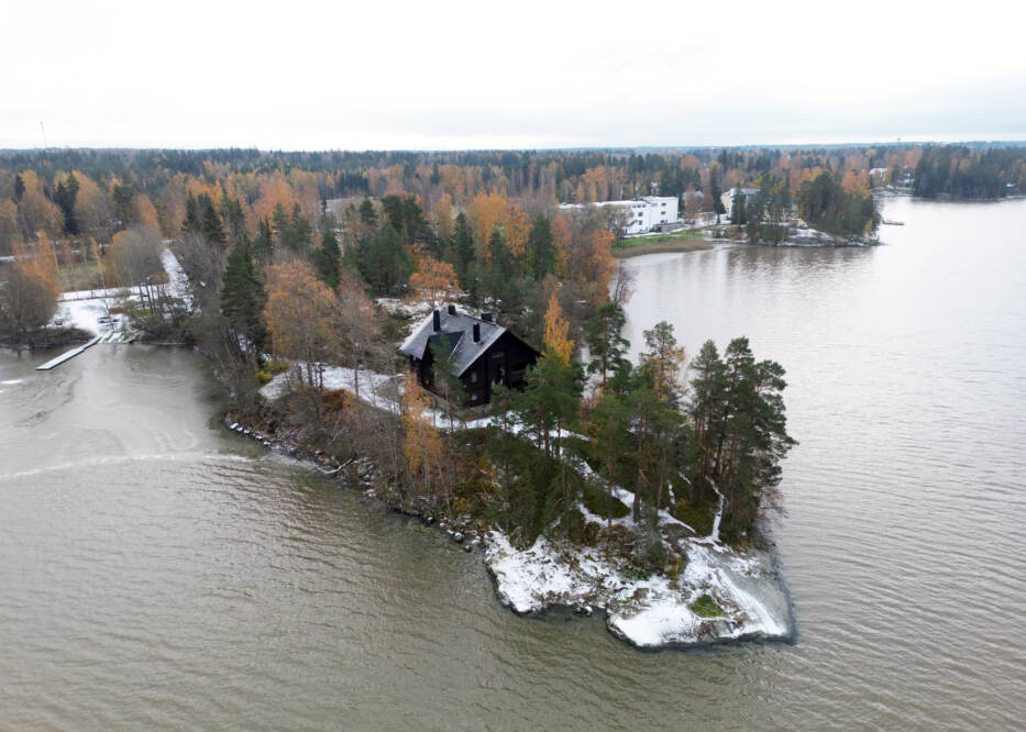 Ilmakuvassa näkyy terävä niemi, järvi niemen molemmin puolin. Kuvan keskellä korkea hirsinen rakennus.